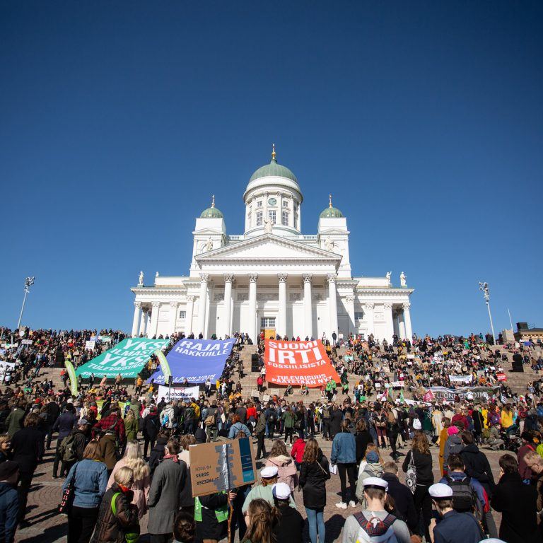 Kuva ilmastomarssilta 2019. Kuvassa joukko ihmisiä ja Helsingin tuomikirkko.