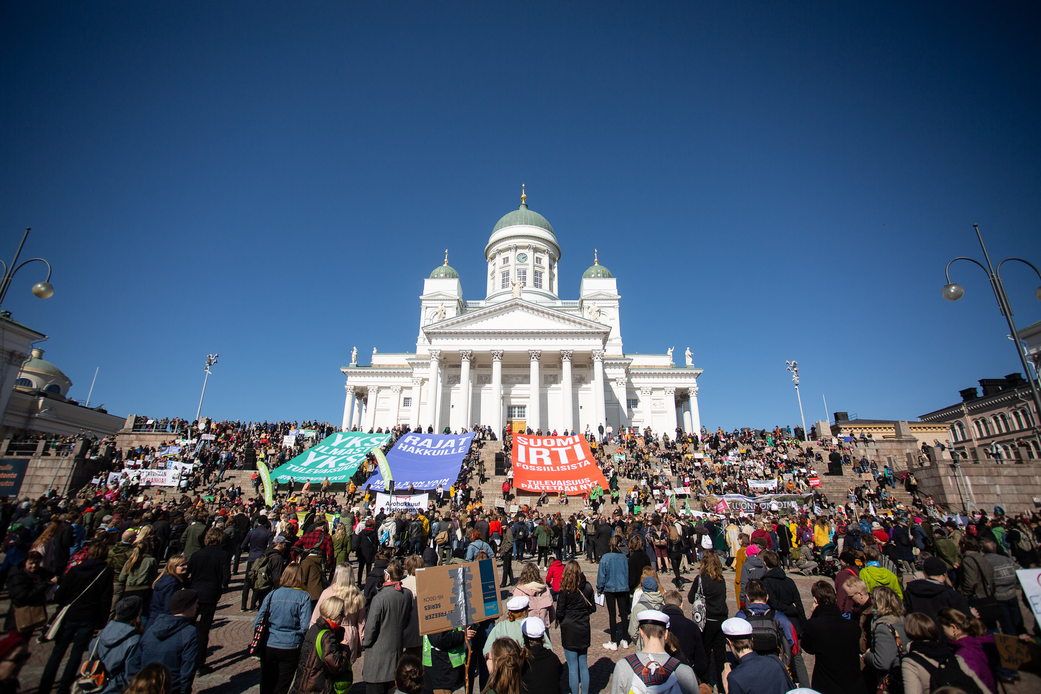 Kuva ilmastomarssilta 2019. Kuvassa joukko ihmisiä ja Helsingin tuomikirkko.