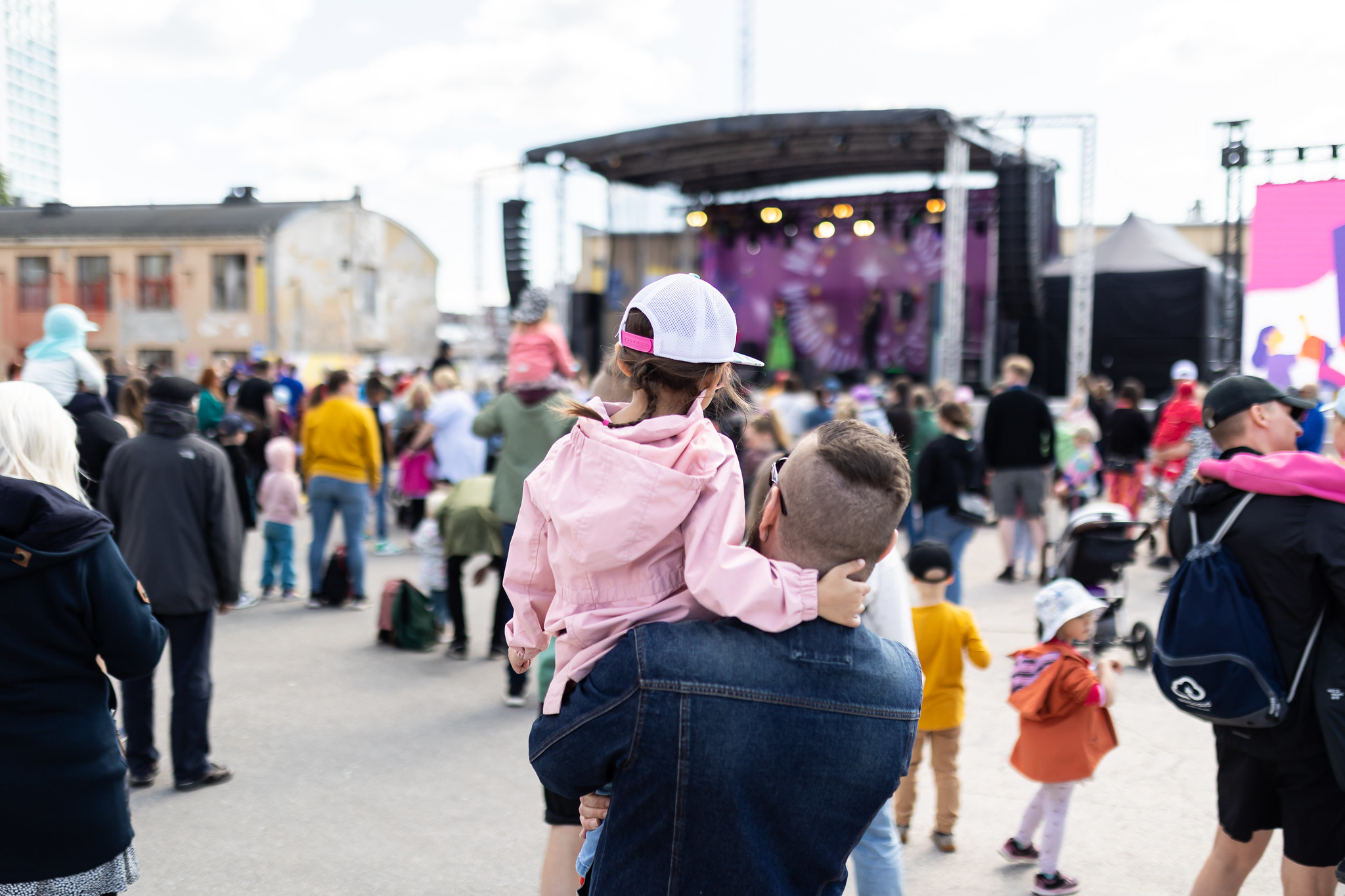 Lapsi ja vanhempi sekä muuta yleisöä Musiikkilavan edustalla.